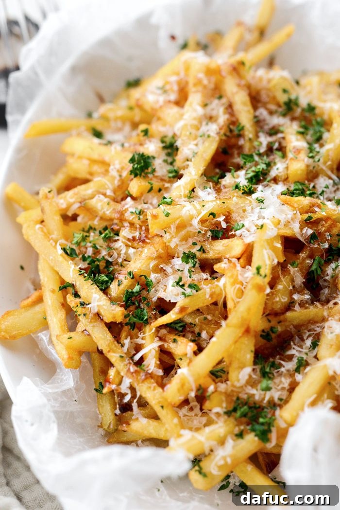 Decadent Truffle Parmesan Fries 14 A large serving of Parmesan Truffle Fries on a rustic wooden board, ready for sharing