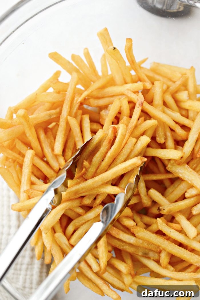 Decadent Truffle Parmesan Fries 7 Gently tossing French fries coated with truffle oil in a mixing bowl