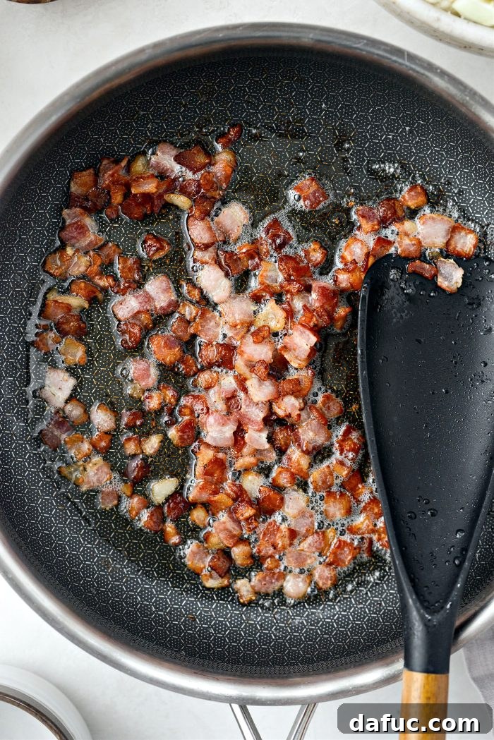 Crispy Bacon & Cheddar Roasted Cauliflower 6 Crispy bacon pieces in a skillet, nearly done cooking