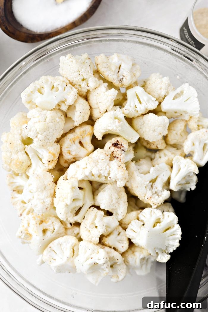 Crispy Bacon & Cheddar Roasted Cauliflower 8 Tossing cauliflower florets with seasoning and bacon fat in a bowl