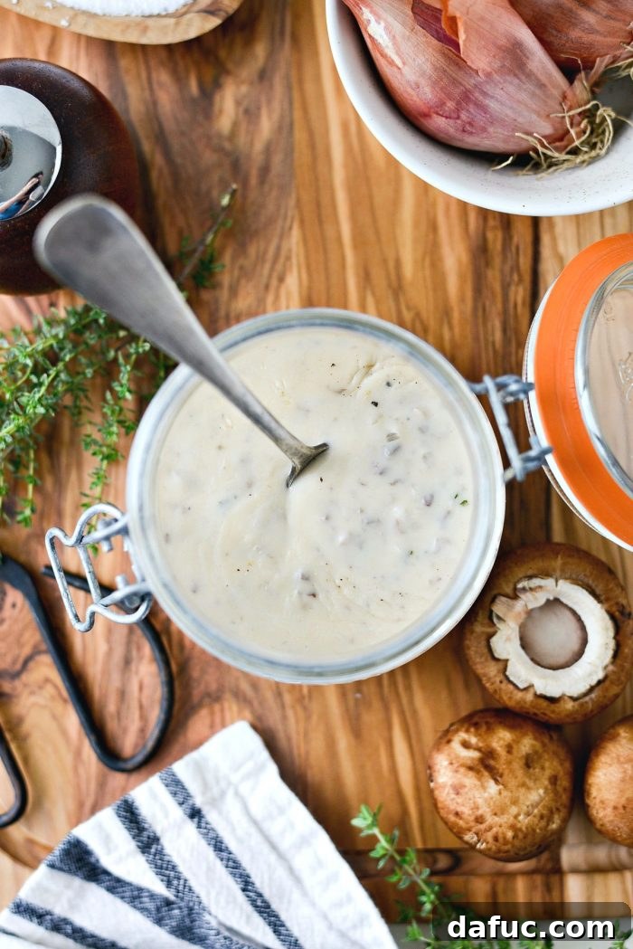Final presentation of homemade condensed cream of mushroom soup in a stylish bowl with garnishes.