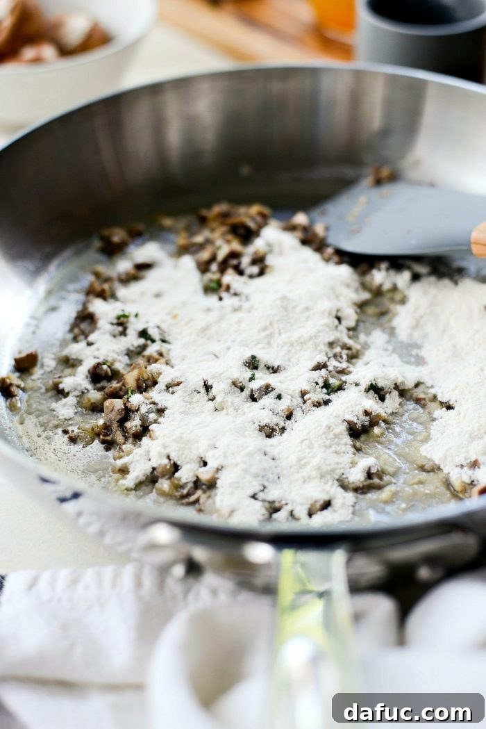 Sprinkling unbleached all-purpose flour over the cooked mushrooms and shallots to create a roux.