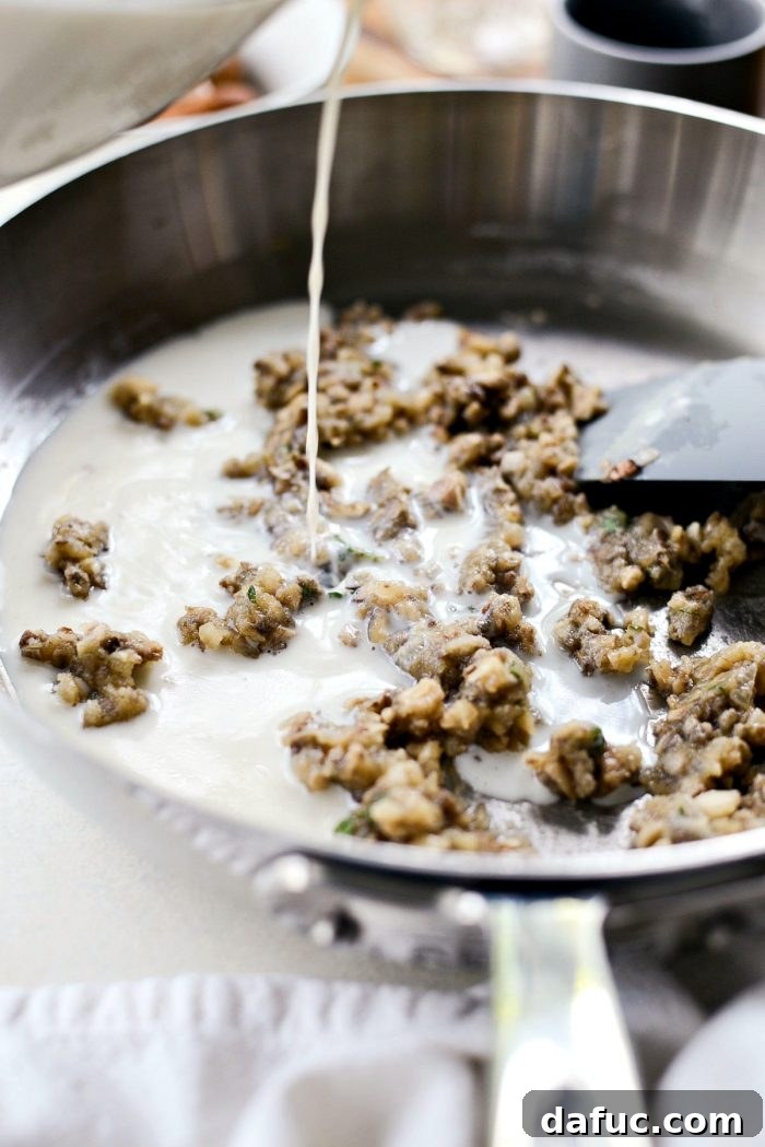 Whisking the combined milk and vegetable broth into the roux until the mixture is smooth.