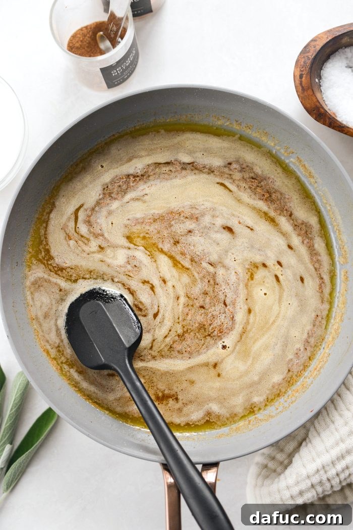 Stirring to combine the bourbon maple butter mixture in a skillet