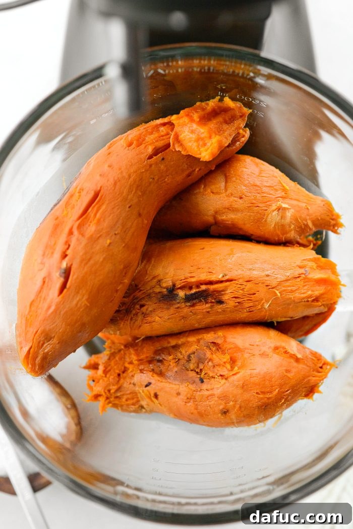 Adding roasted sweet potatoes to a stand mixer for mashing