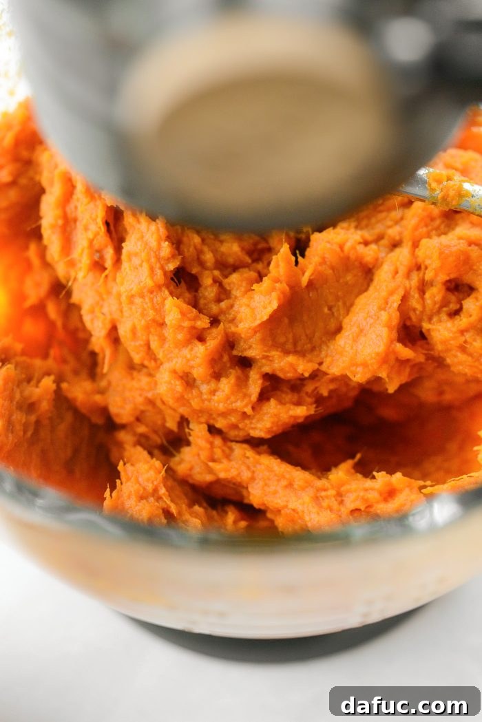 Mixing sweet potatoes until smooth in a stand mixer