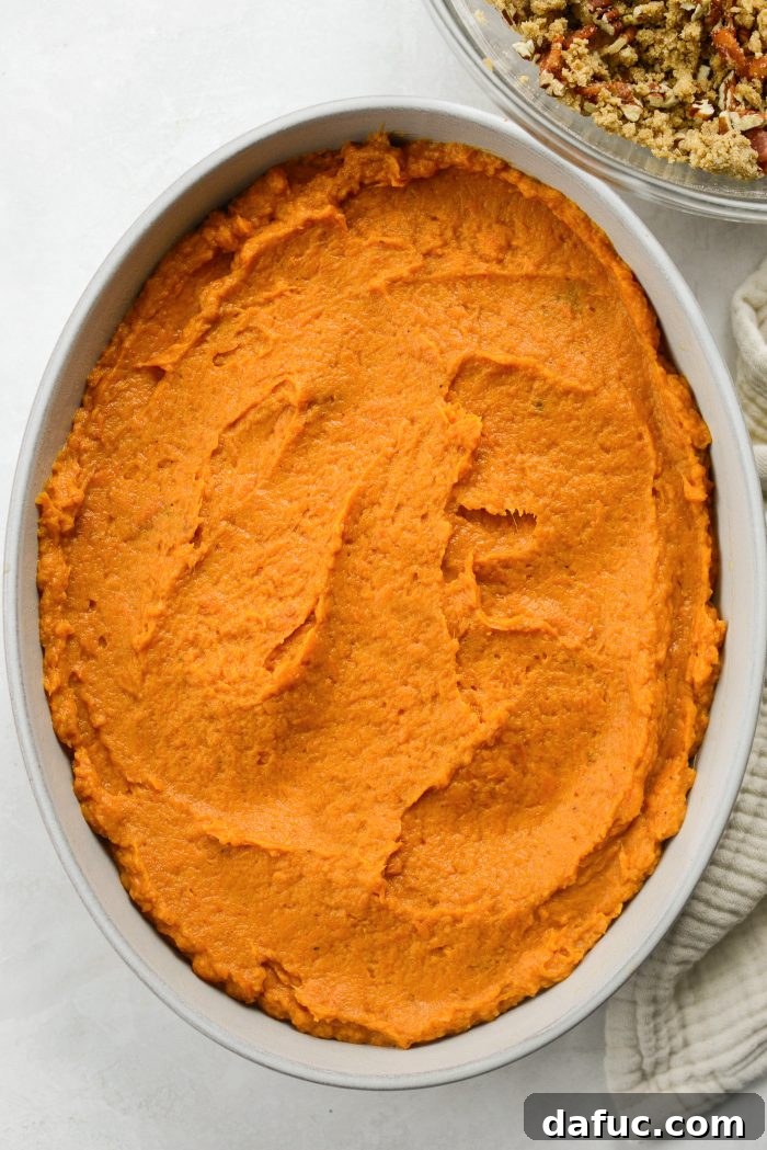 Spreading sweet potato mixture smooth in a casserole dish