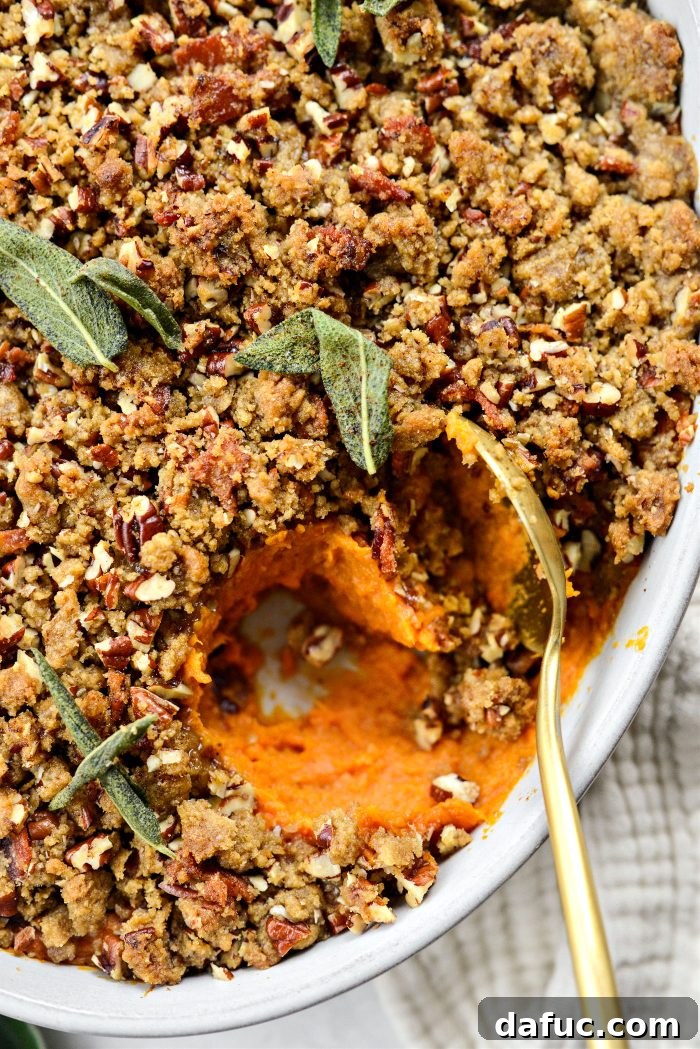 Scooping generous portions of Maple Bourbon Bacon Sweet Potato Casserole onto a plate