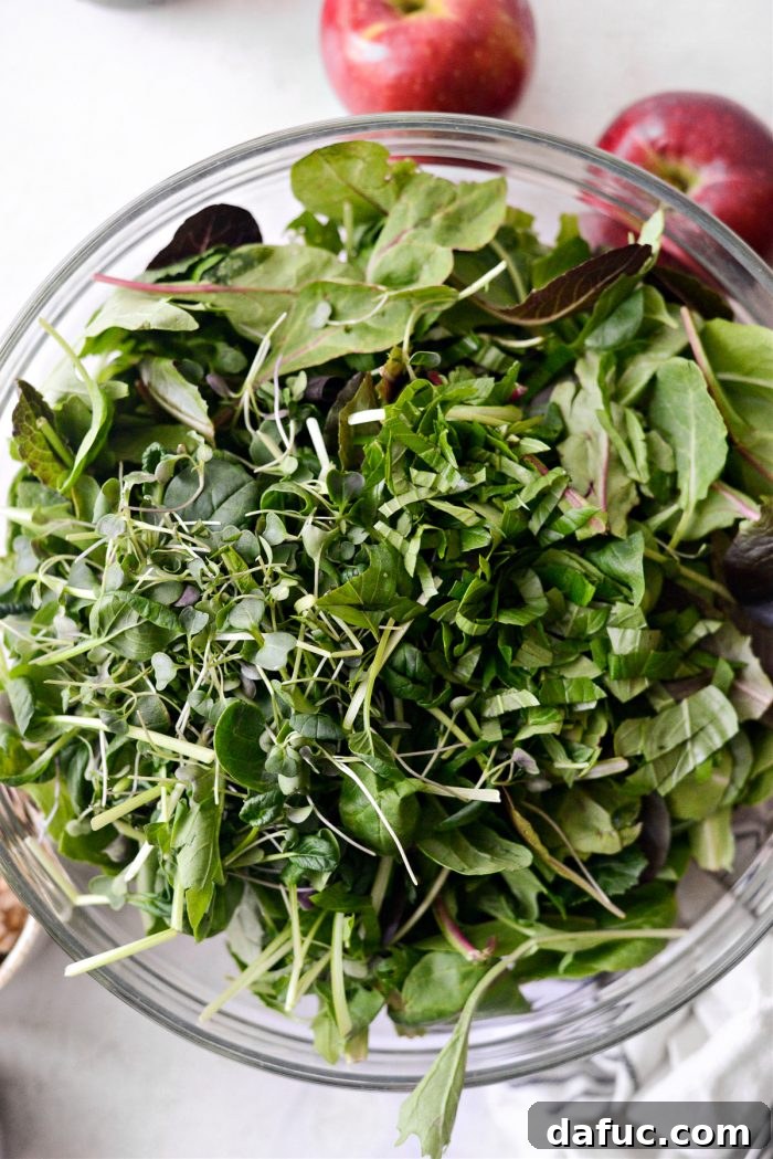 mixed salad greens, micro greens and chopped basil in bowl