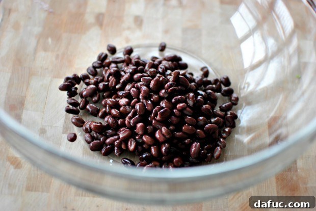 Adding black beans to a bowl