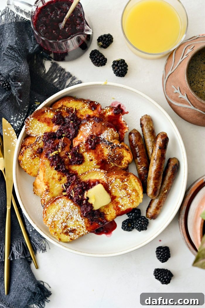 Sourdough French Toast with Berry Compote 21 A plate of Buttermilk French Toast with maple blackberry sauce, salted butter, and lemon zest