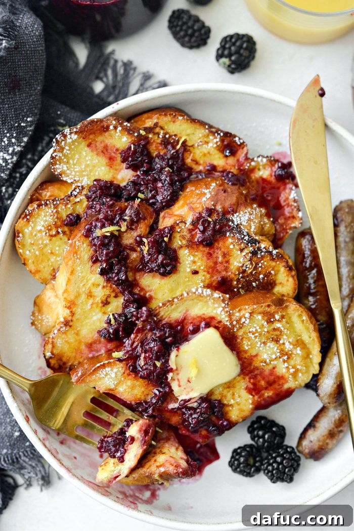 Sourdough French Toast with Berry Compote 25 Buttermilk French Toast with melted butter, syrup, and berries on a white plate