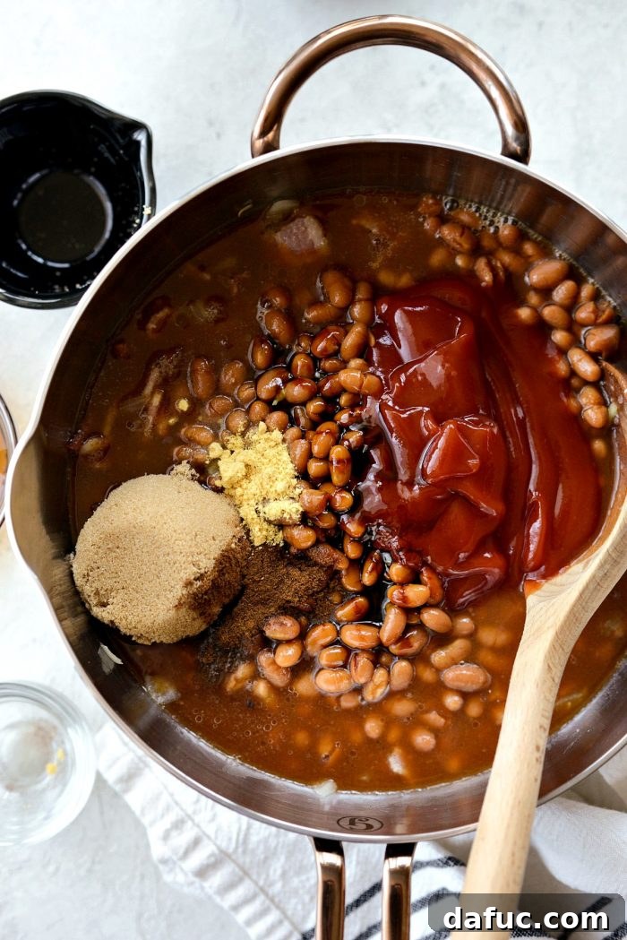 Hearty Homestyle Baked Beans 7 Adding ketchup, molasses, brown sugar, and spices to the pot with bacon and onions