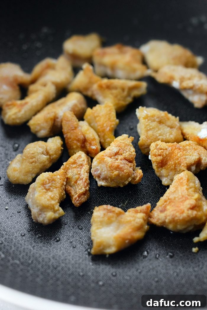 Sticky Sweet Bourbon Chicken 12 Removing browned chicken from the pan to repeat with more batches