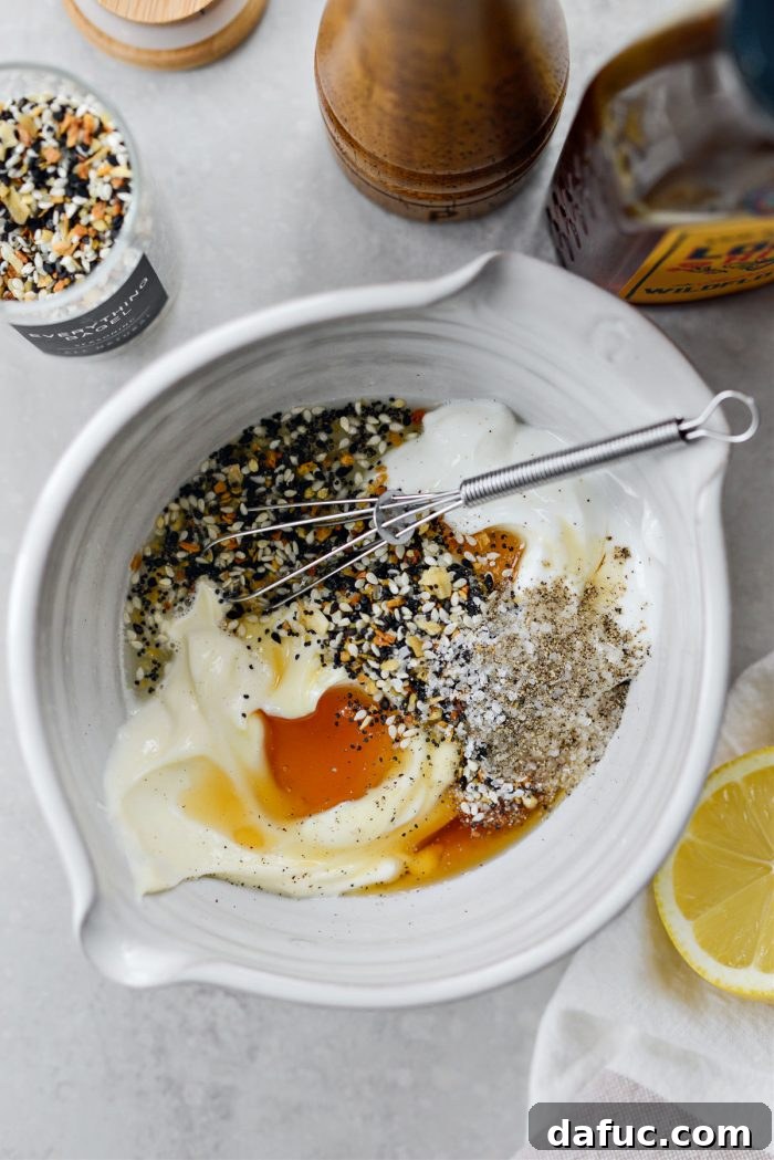 Ingredients for the creamy dressing, including Greek yogurt, mayonnaise, honey, and lemon juice, in a small bowl.