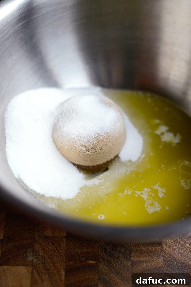 Golden Molasses Chews 5 Combining both sugars and melted butter in a large bowl for molasses cookies.