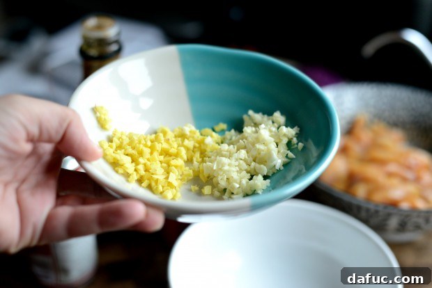 Adding minced ginger and garlic to sauce