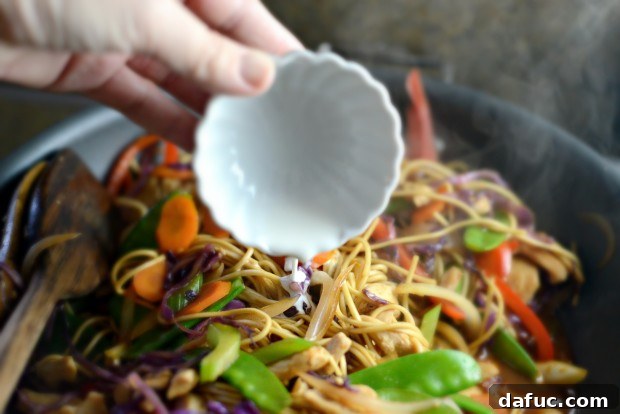 Adding cornstarch slurry to thickening stir-fry sauce