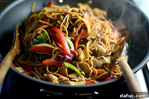 Tossing chicken and vegetables with thickened sauce