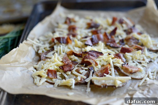 An even layer of grated Irish cheese sprinkled over the first layer of potato rounds.