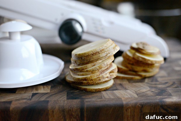 A mandoline slicer with a russet potato, demonstrating the essential tool for achieving perfectly thin and even potato slices for Irish Nachos.