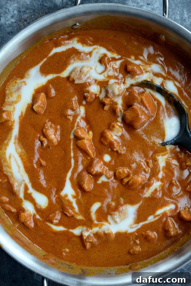 The Ultimate Chicken Tikka Masala 6 Adding marinated chicken to a skillet with coconut cream and spices