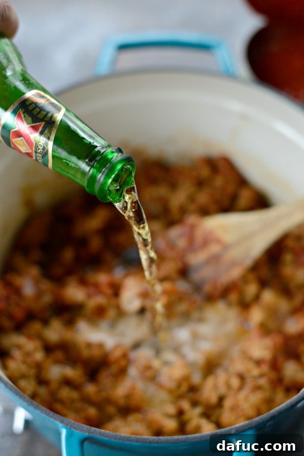 Pouring beer into the chili base