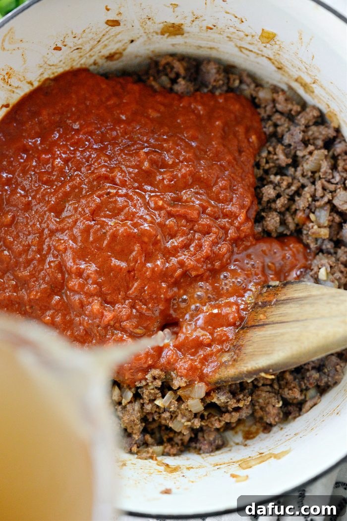 Effortless One-Pan Spaghetti 11 marinara and broth added to beef and sausage