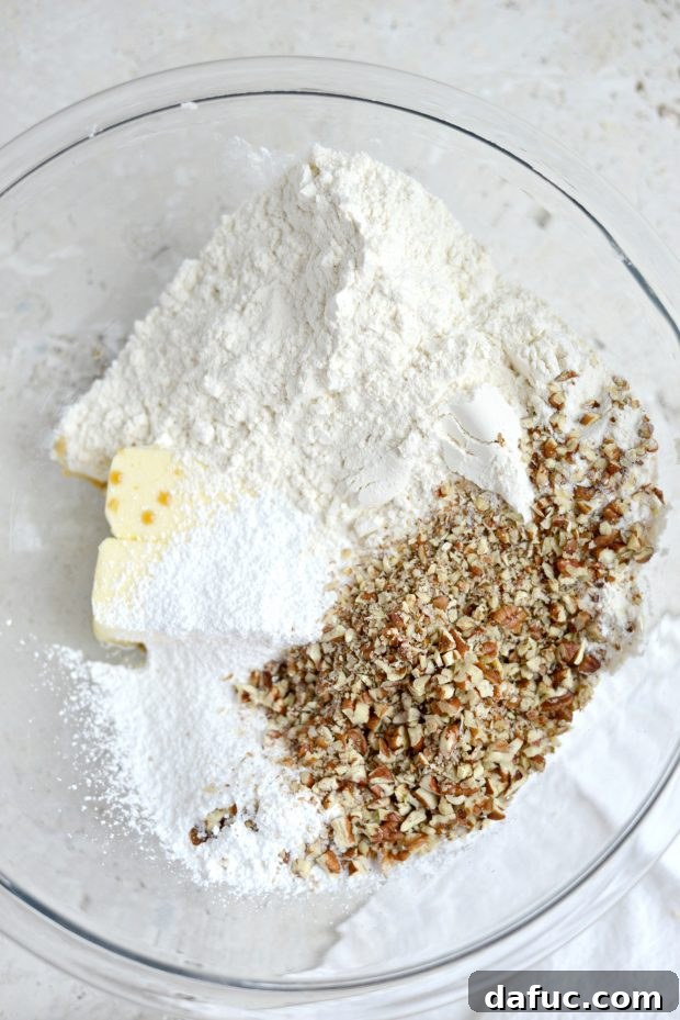 Pecan Dreamscape 4 Ingredients for Pecan Dreams Snowball Cookies laid out on a table: butter, flour, pecans, powdered sugar, vanilla extract, and salt.