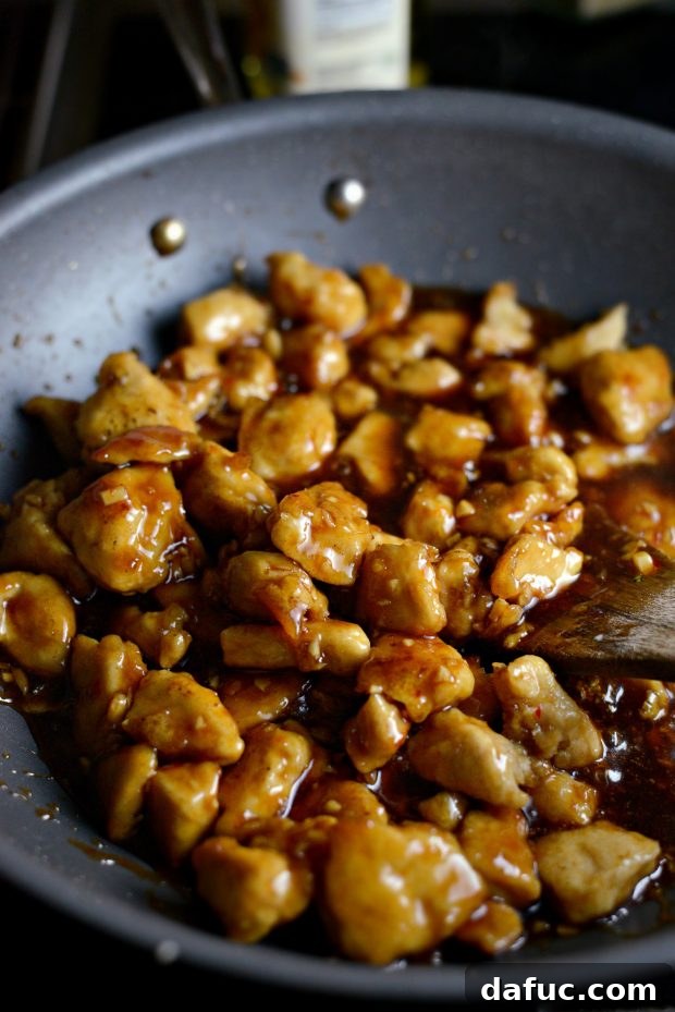 Zesty Ginger Sesame Chicken Stir-Fry 9 Sauce thickening around chicken in the wok