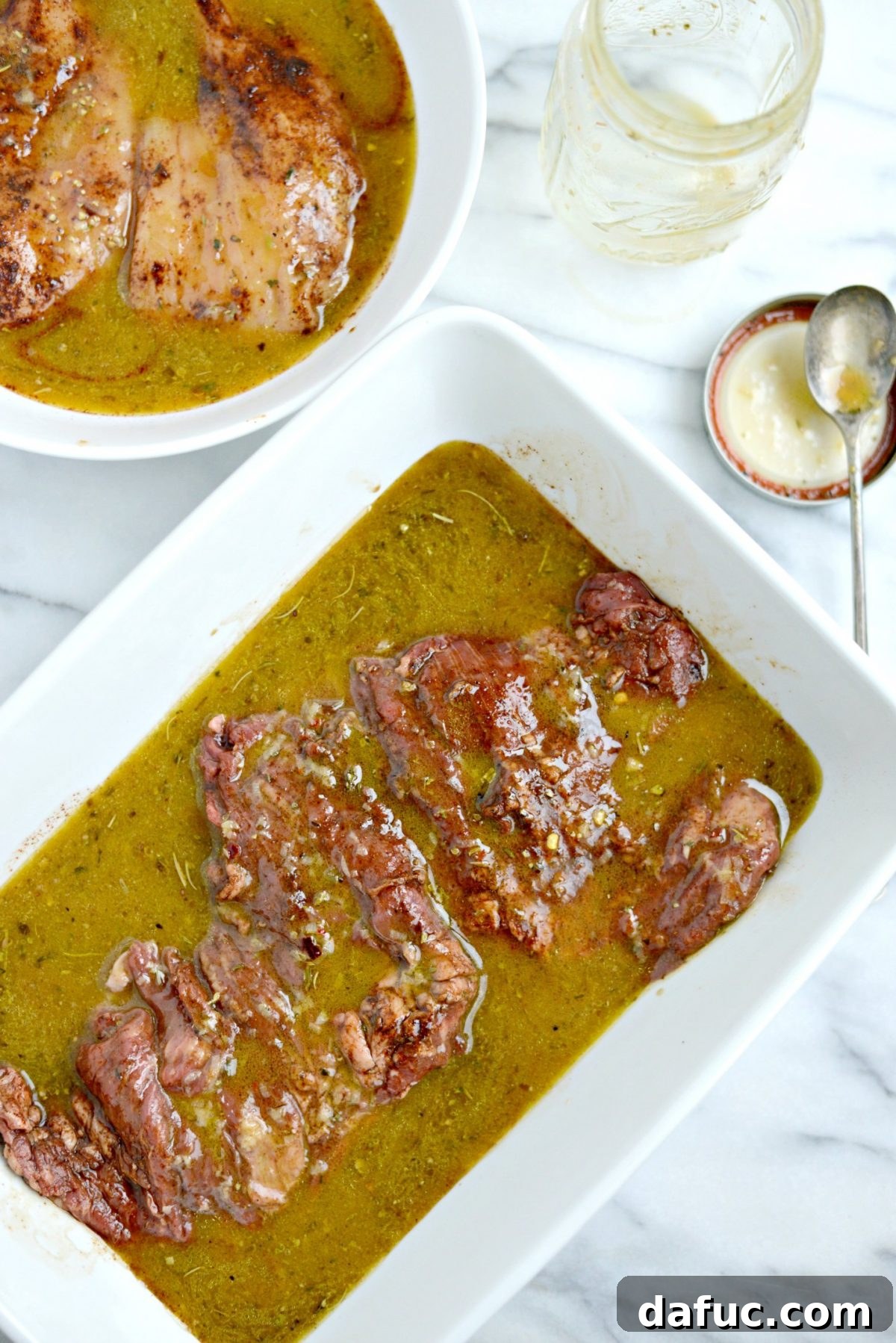 Steak and chicken marinating in dishes, covered