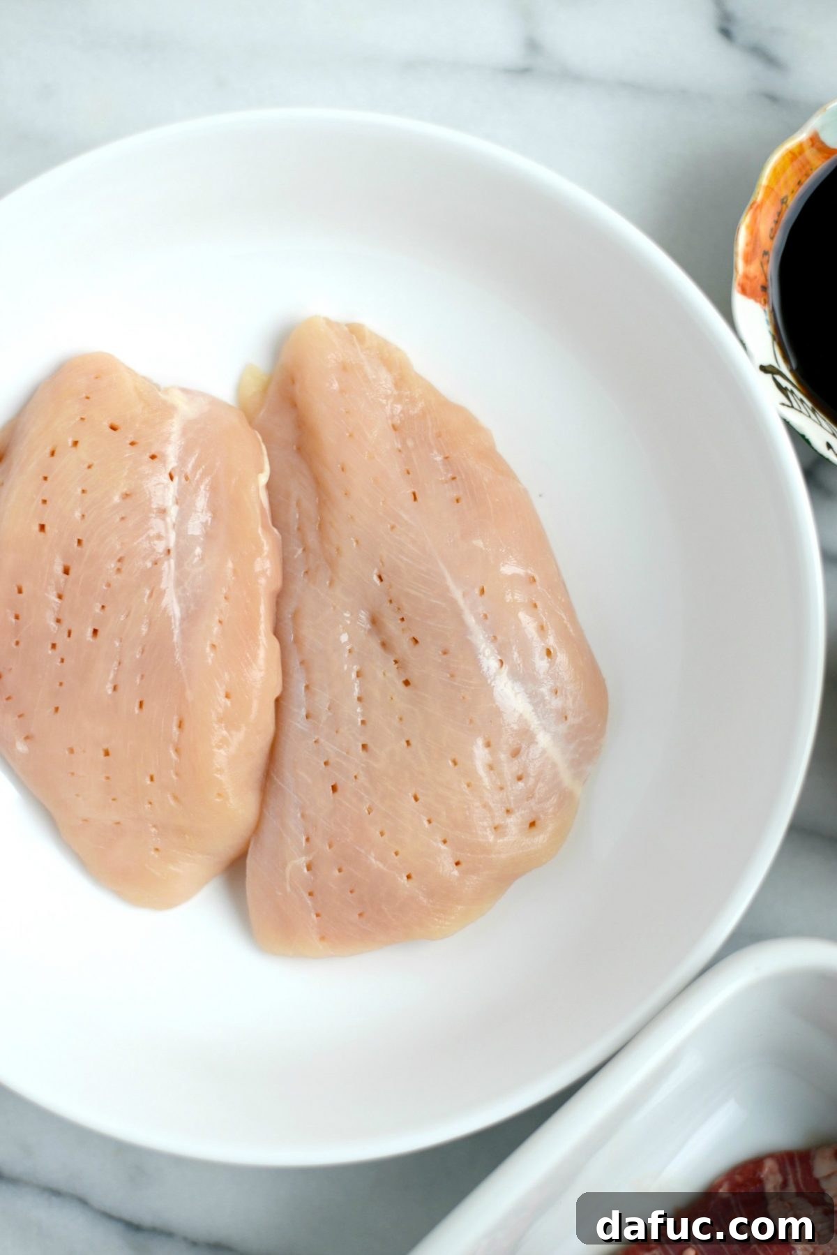 Pricking chicken breasts with a fork for marinade penetration