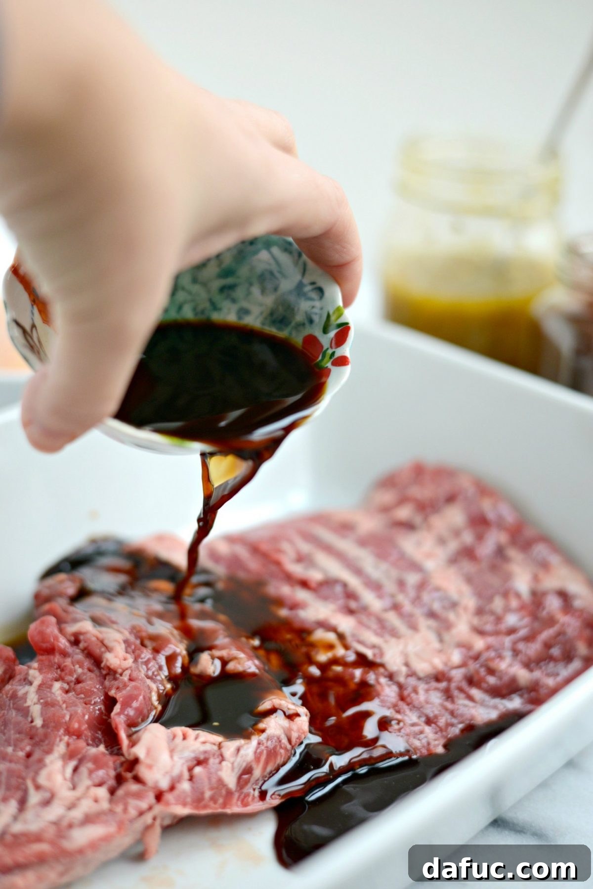 Pouring Worcestershire sauce over skirt steak