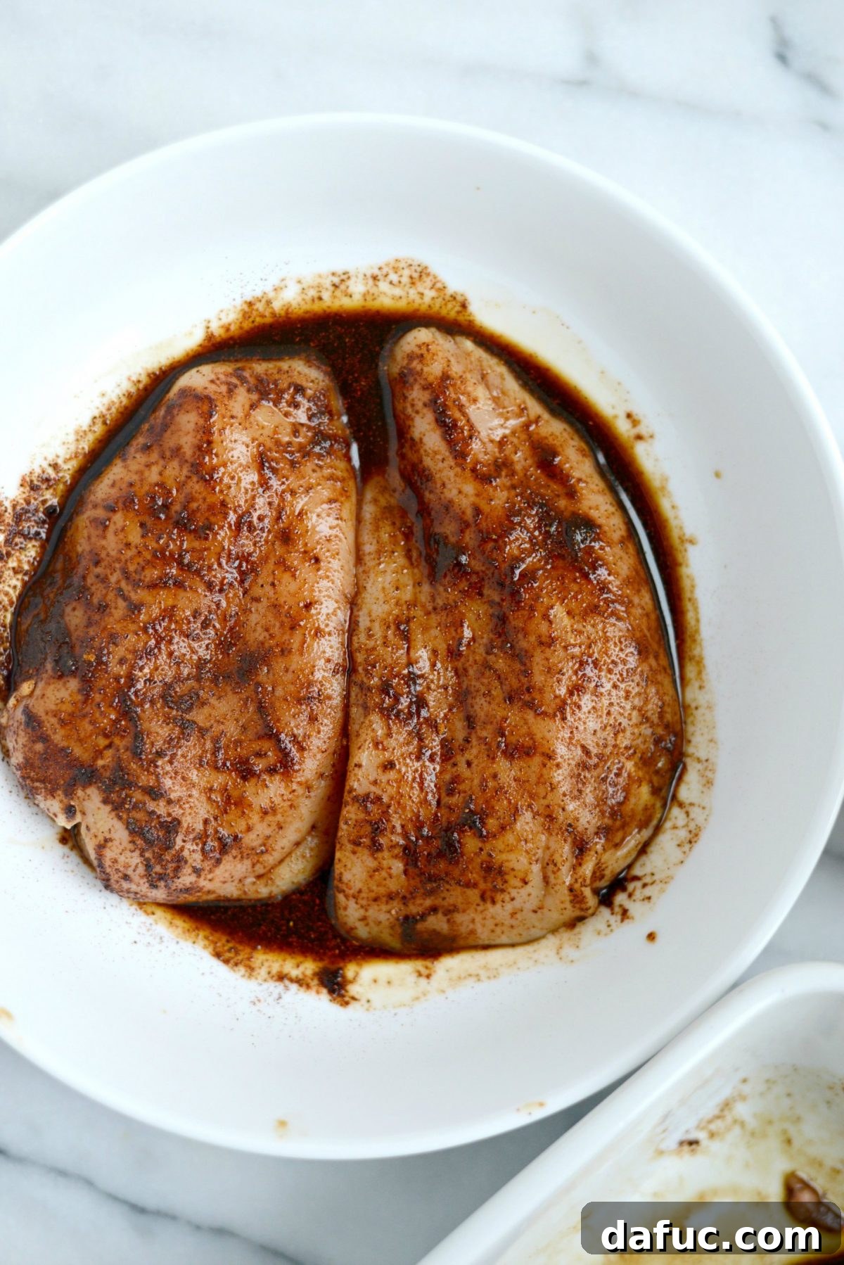 Chicken marinating in spices and Worcestershire sauce