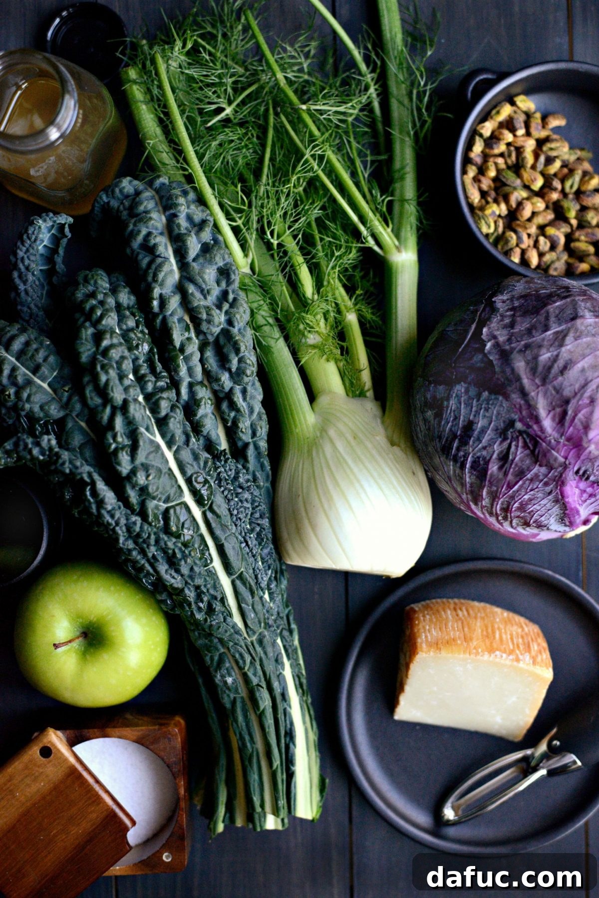 Ingredients laid out for making Kale, Fennel and Apple Salad, including kale, fennel, cabbage, and apples.