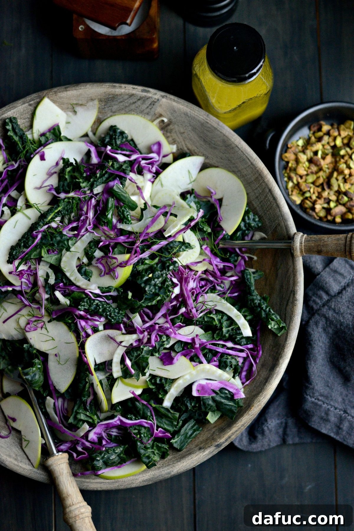 Tossing Kale, Fennel, and Apple Salad with vinaigrette.