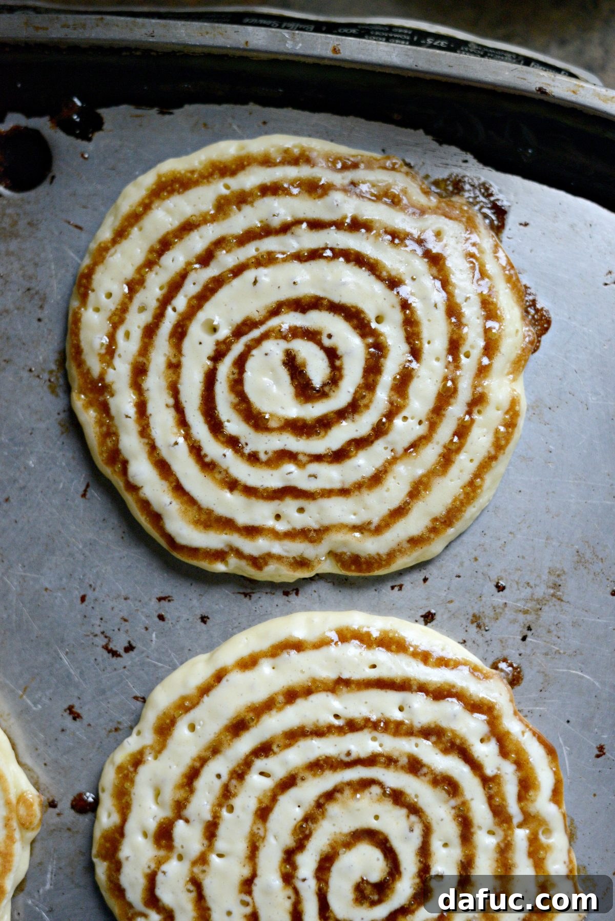 Dreamy Cinnamon Swirl Stacks 14 A pancake with a cinnamon swirl on the griddle