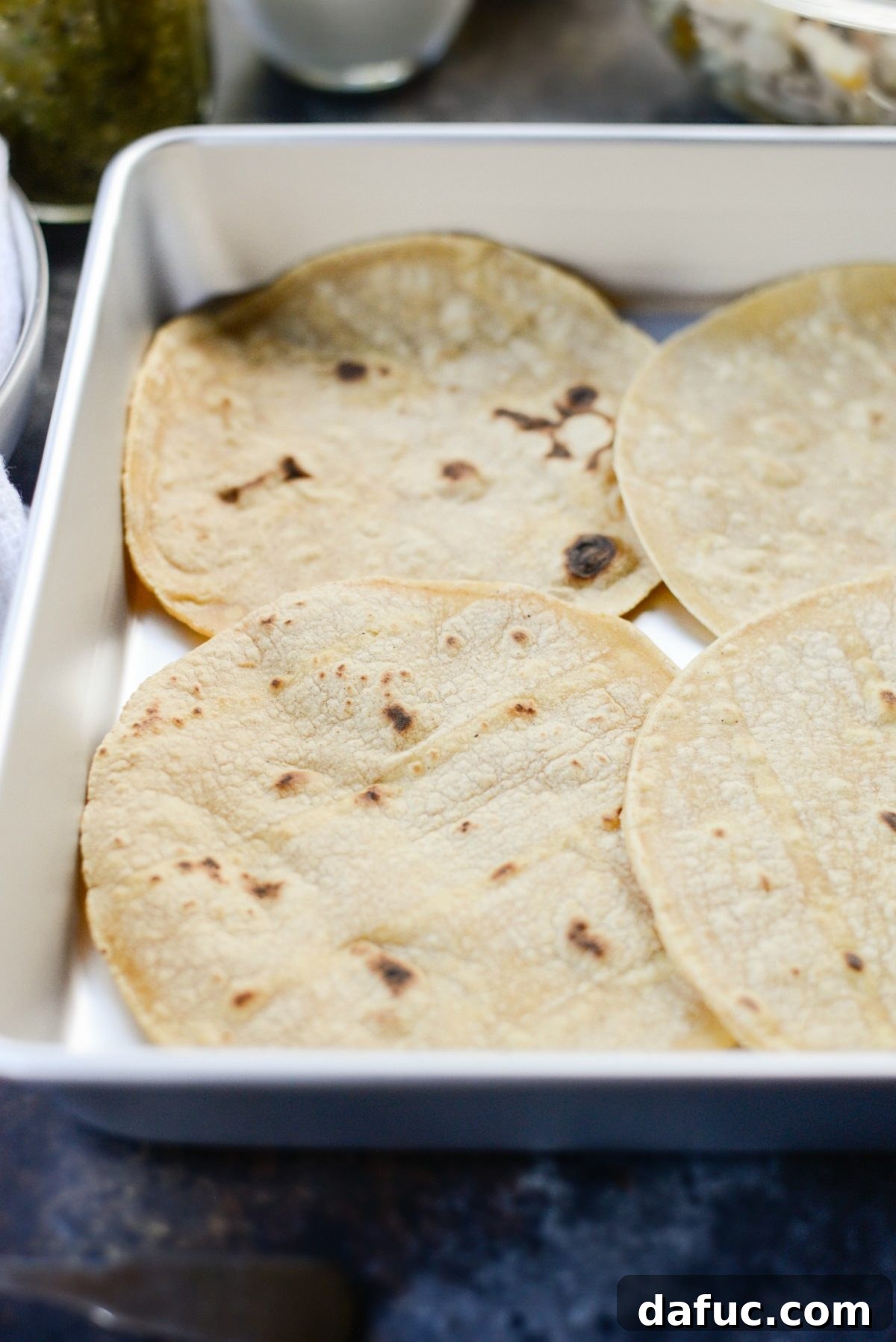 Green Chile Chicken Tortilla Bake 7 Layer of toasted corn tortillas in a baking pan for casserole