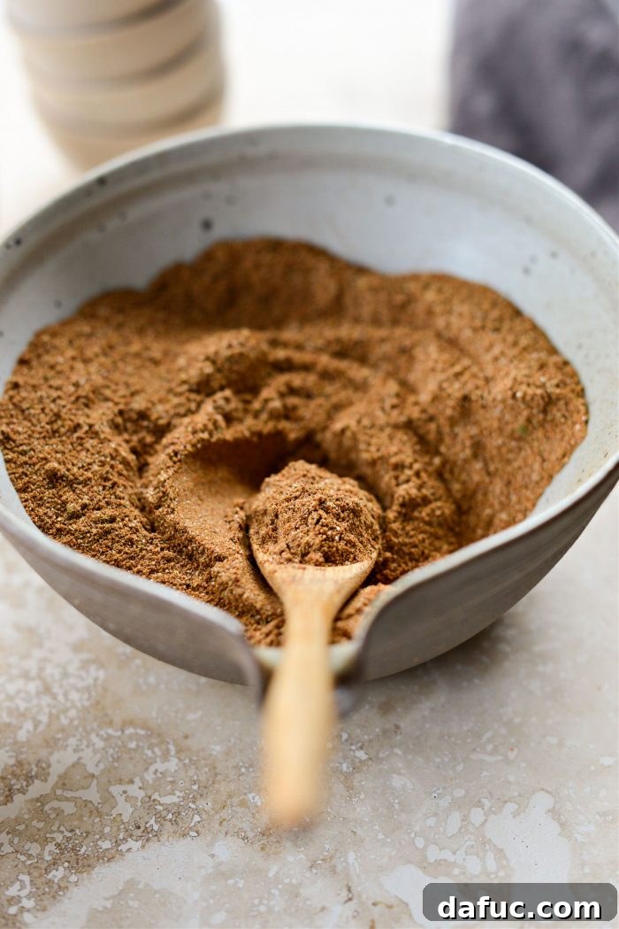 DIY Shawarma Spice Mix 9 Homemade Shawarma Seasoning in a jar with a wooden spoon and scattered spices