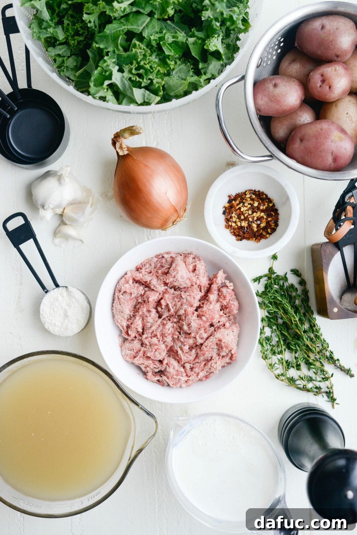 A large Dutch oven filled with Creamy Potato, Sausage and Kale Soup, steaming and ready to serve.