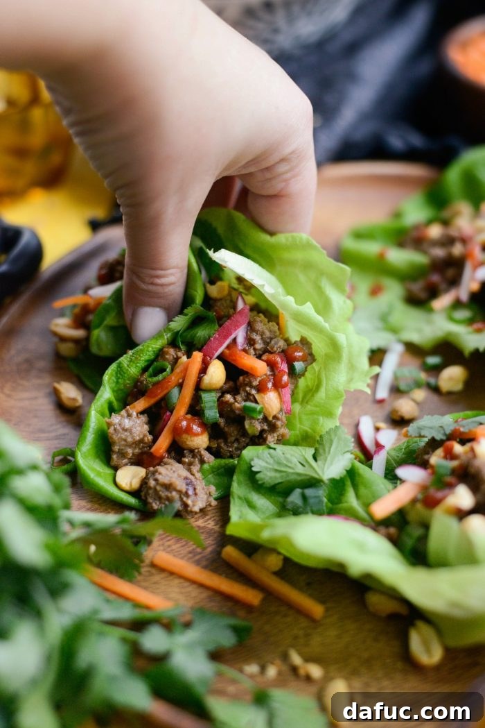 Delicious Ginger Beef Lettuce Wraps, ready to be enjoyed with sriracha.
