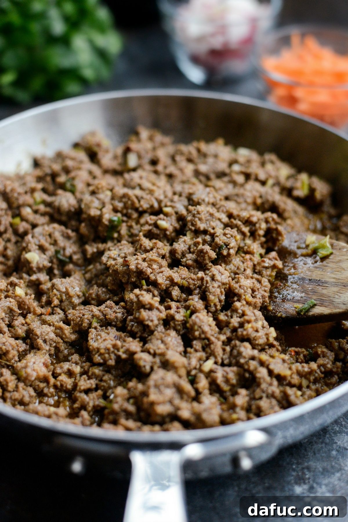 Simmering the ginger beef until the sauce is rich and thickened.