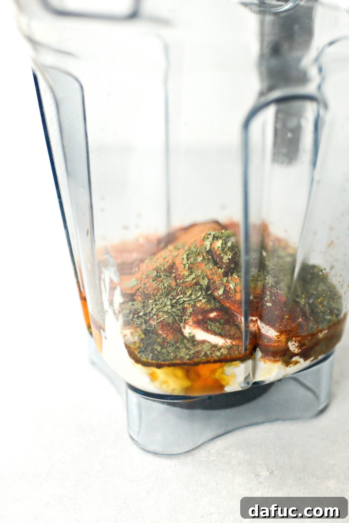 All ingredients for homemade southwest dressing laid out on a counter next to a blender