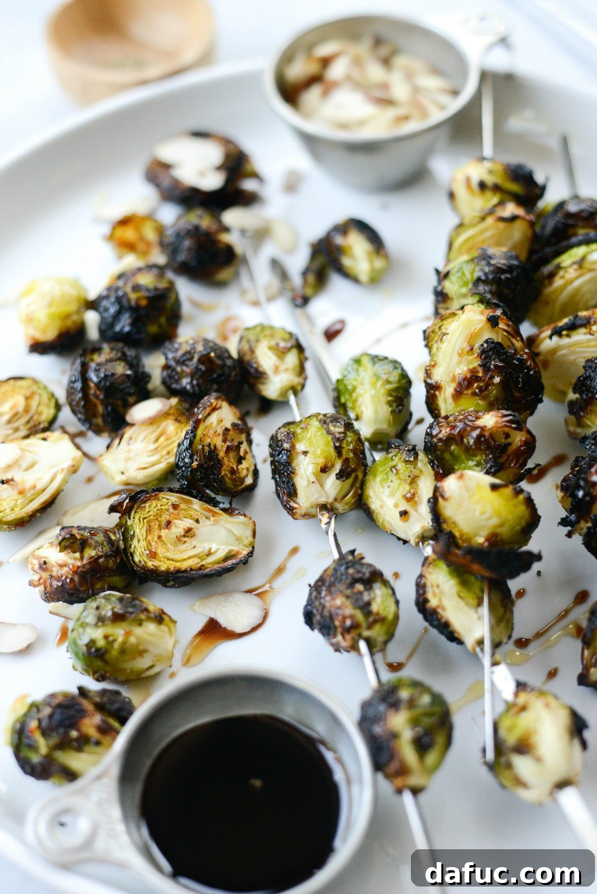 Plated Grilled Garlic Brussels Sprouts with honey, balsamic, and almonds