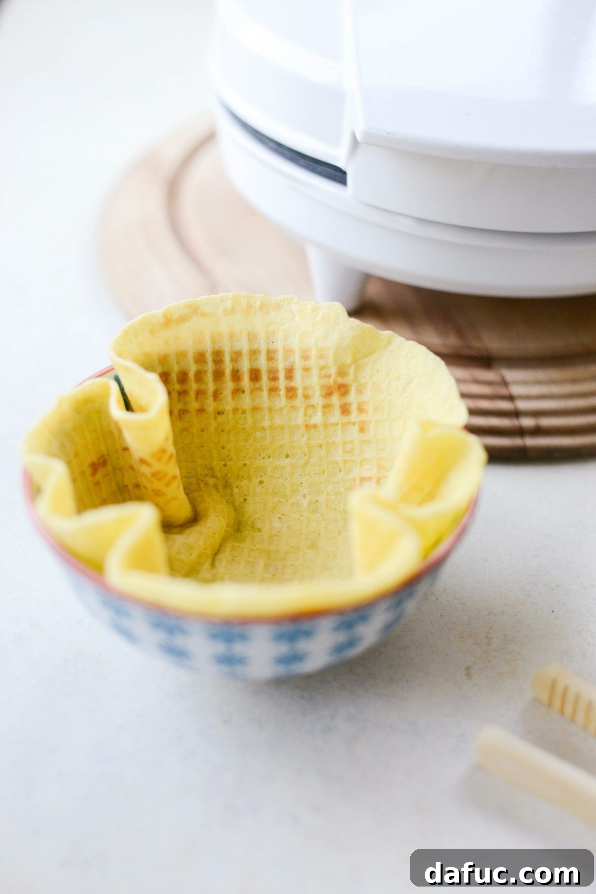 Fitting a warm waffle into a small bowl for shaping