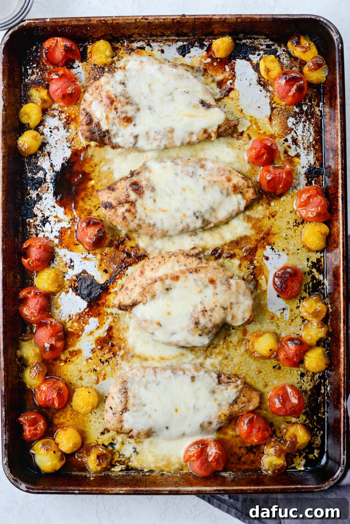 Melted mozzarella cheese on baked chicken breasts