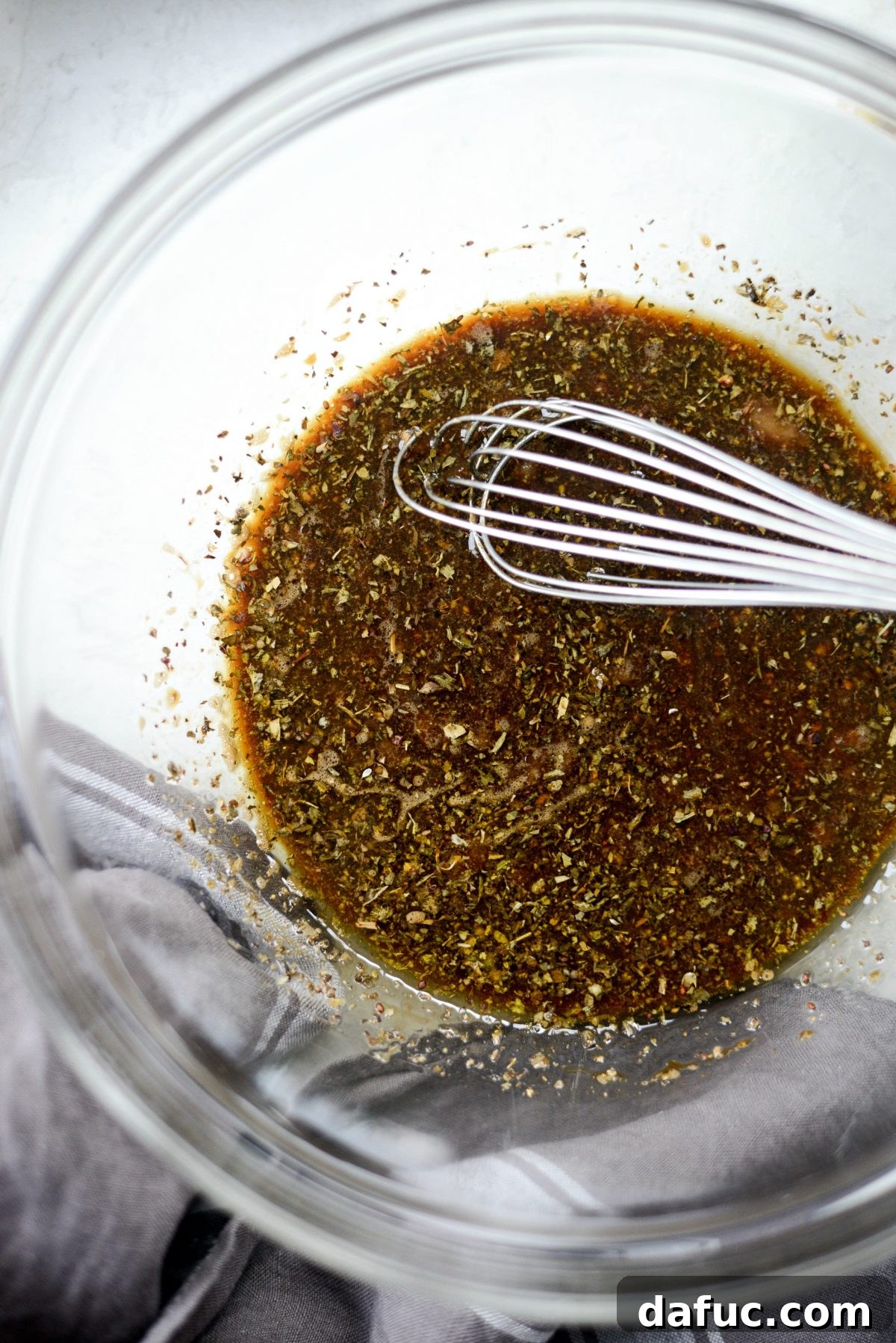 Whisking balsamic basil marinade ingredients