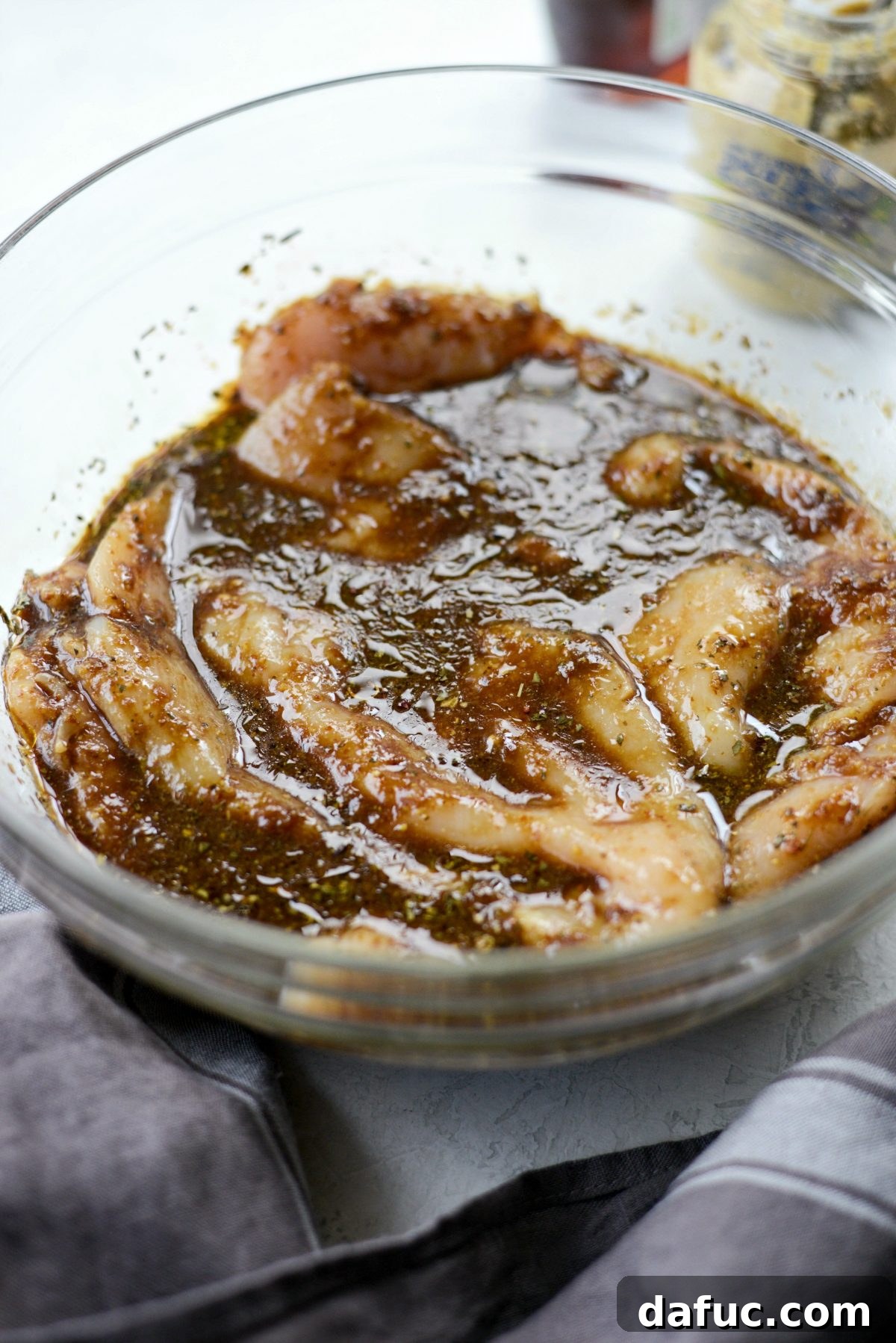Tossing chicken to coat evenly in marinade