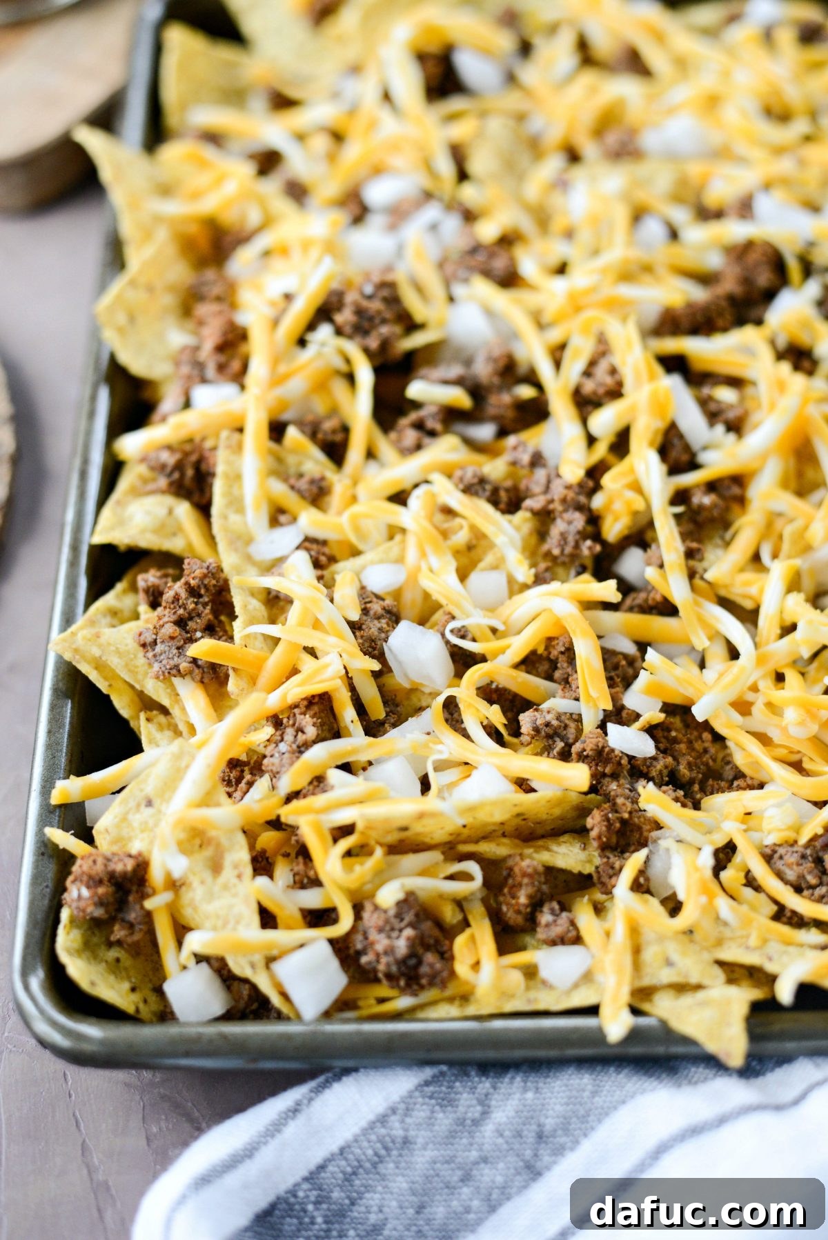 Ultimate Taco Nachos 9 top with more cheese before baking