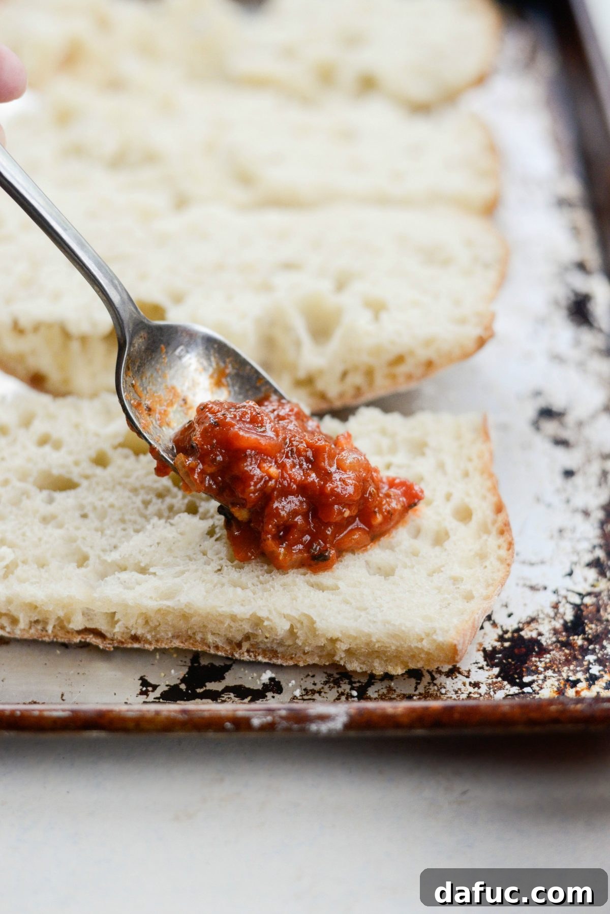 spread sauce onto focaccia pizza base